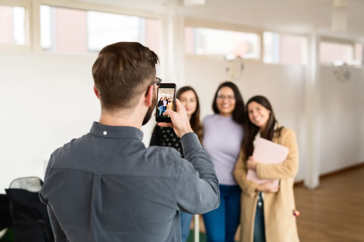 Students at campus Flemingsberg in 2019. || A student is taking a photo of other students with his phone.