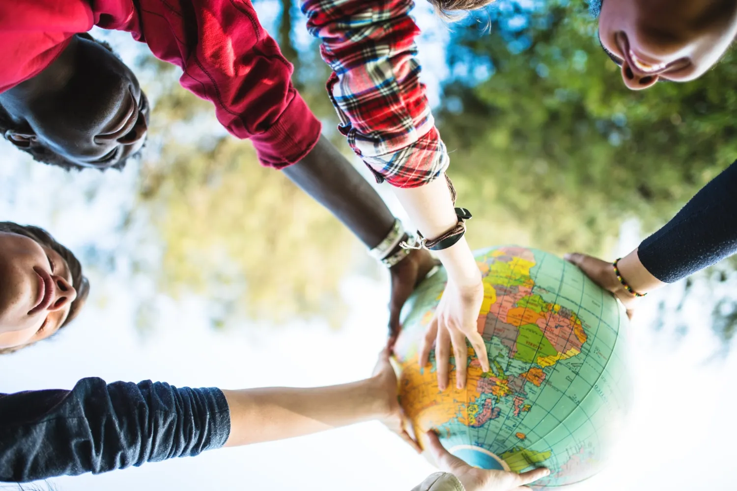 A group of students together holding up a miniature globe.