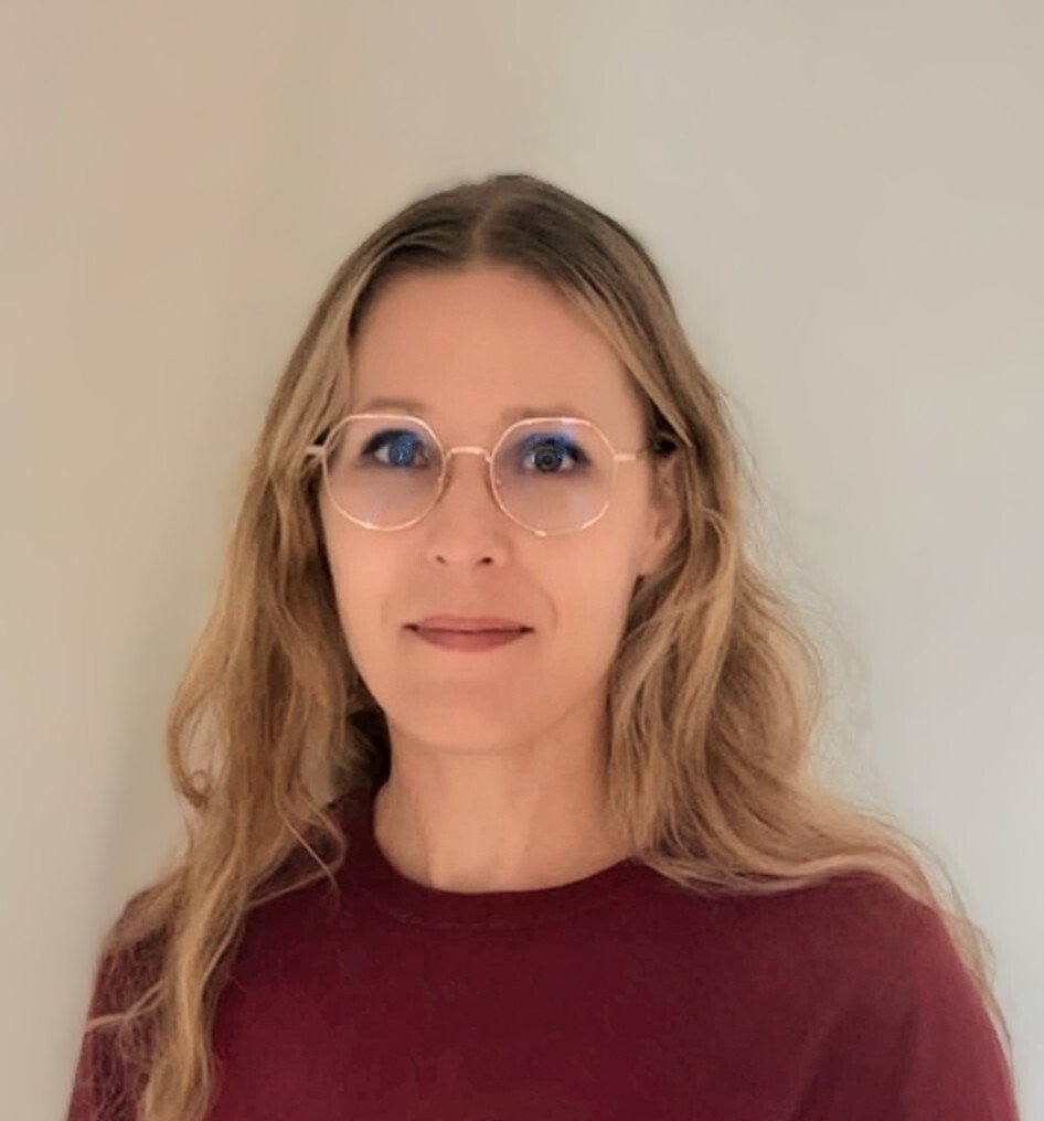 Profile picture of a woman with long blonde hair, glasses and a burgundy top