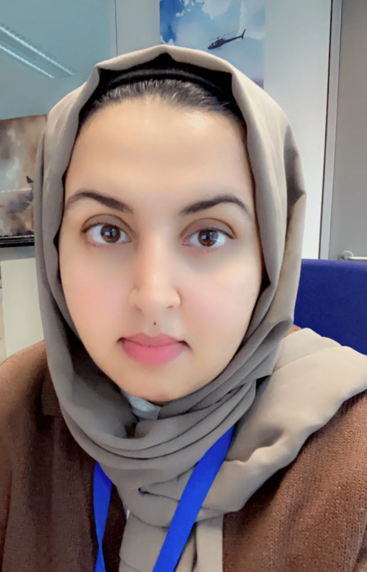 A woman with dark hair and a grey head scarf