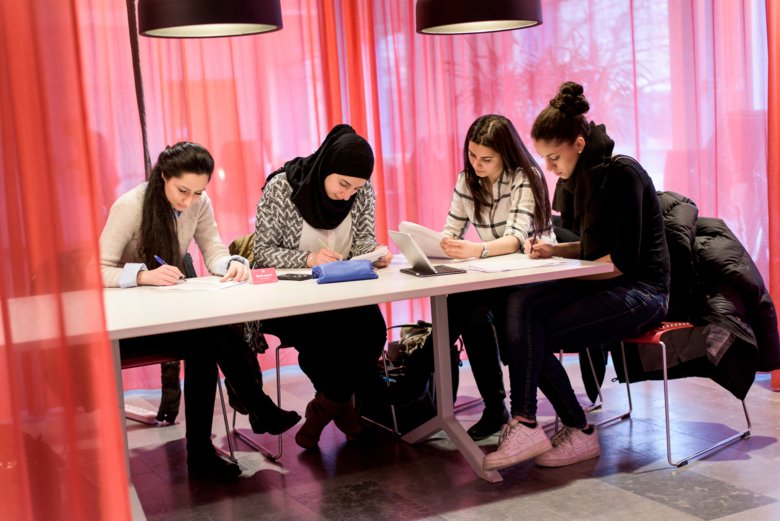 Four persons at a table are talking