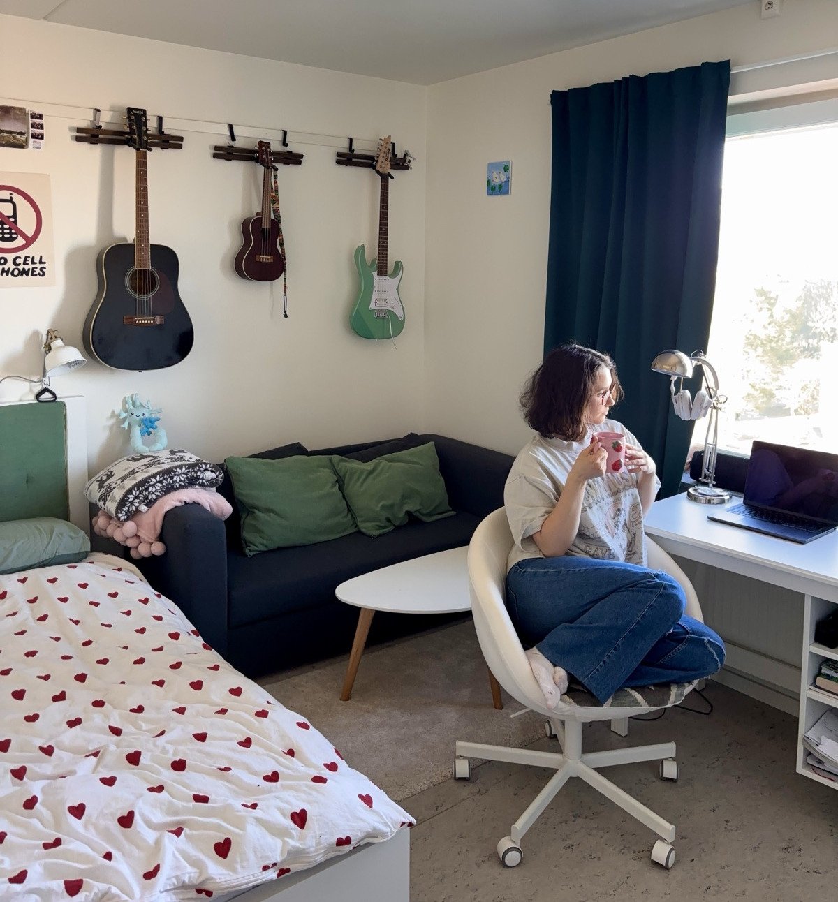 Student in their student room looking out through the window.