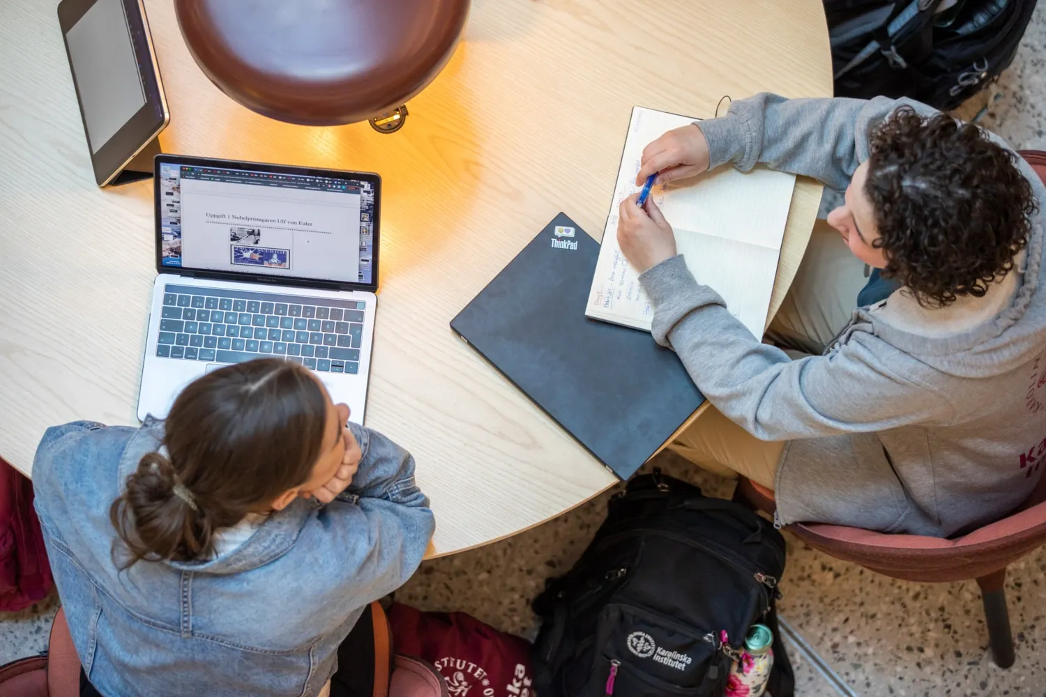 Two students sitting at a table having a conversation