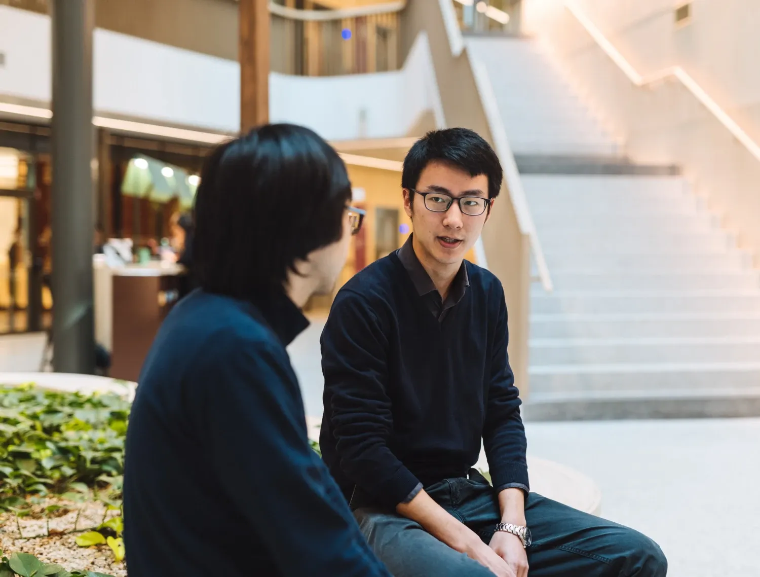 Two students talking in the Biomedicum building.