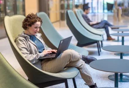 Student at a table in Biomedicum working on their laptop.
